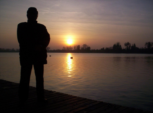 Autor na tle zachodzącego słońca nad jeziorem w Wągrowcu 1listopada 2008 roku,